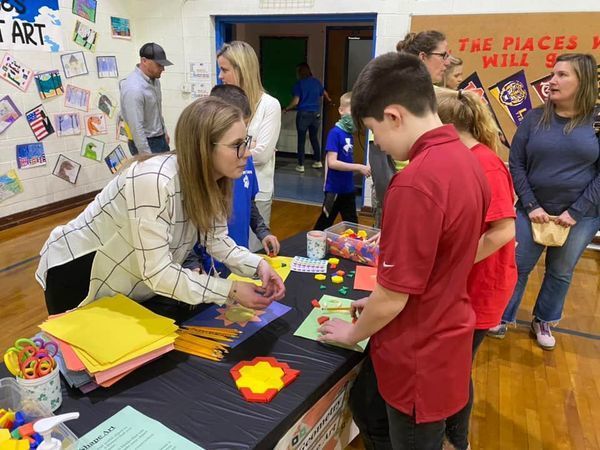 USJ Teacher, Ms. Martin participating in crafts with a student.